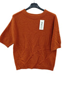An orange short-sleeve knit sweater hanging on a black hanger 
