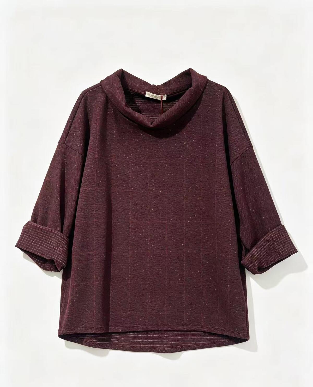 A dark burgundy cowl-neck top with a subtle grid pattern and rolled-up sleeves, displayed against a plain off-white background.