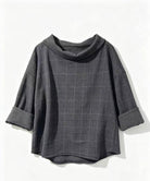 A dark grey cowl-neck top with a subtle check pattern, featuring rolled cuffs, 