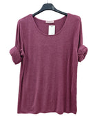 A heathered dusty rose long-sleeve top with rolled-up sleeves, hanging on a black hanger 
