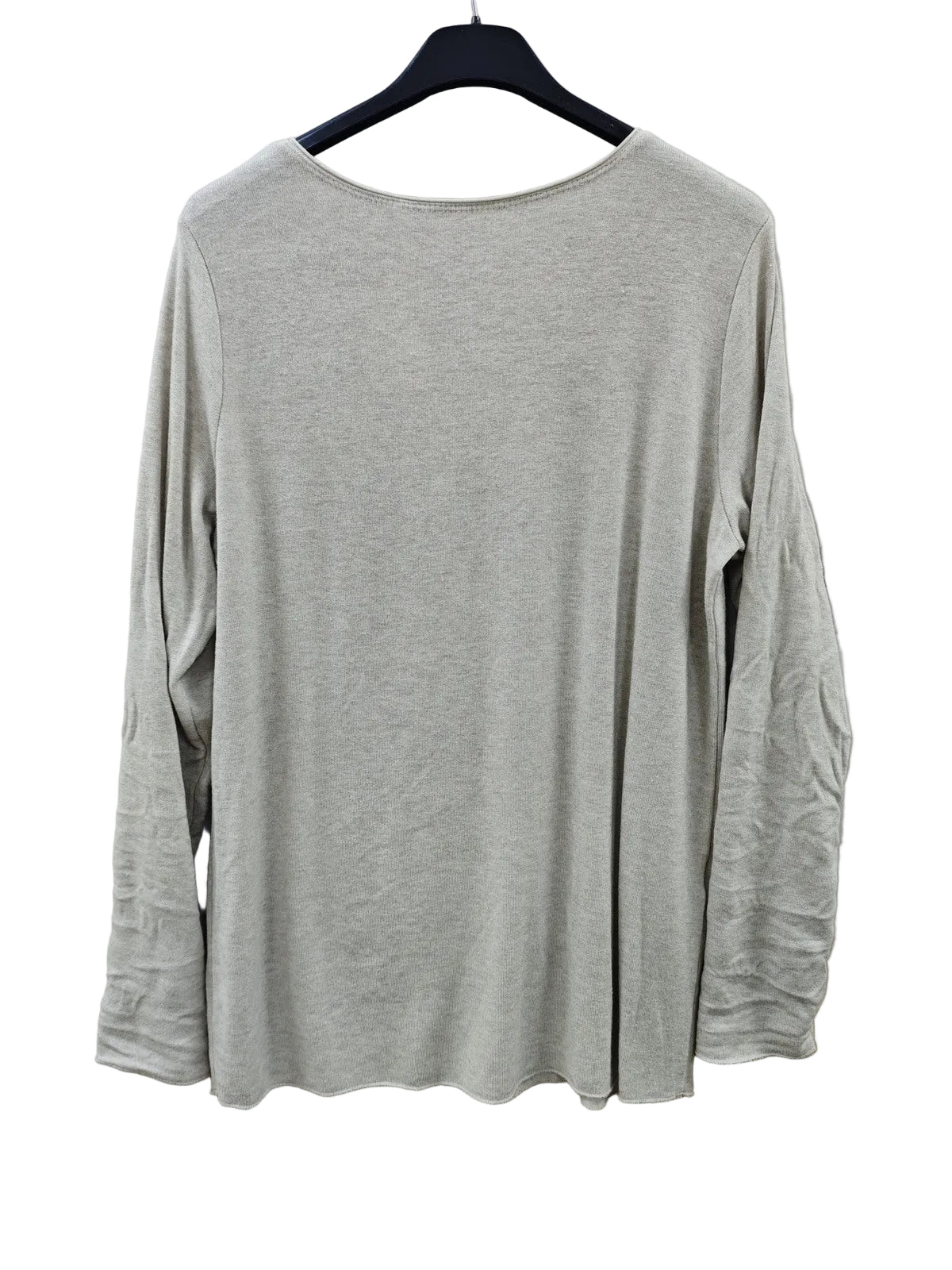 An ivory long-sleeve sweater hanging on a black hanger 