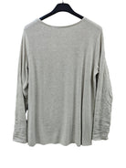 An ivory long-sleeve sweater hanging on a black hanger 