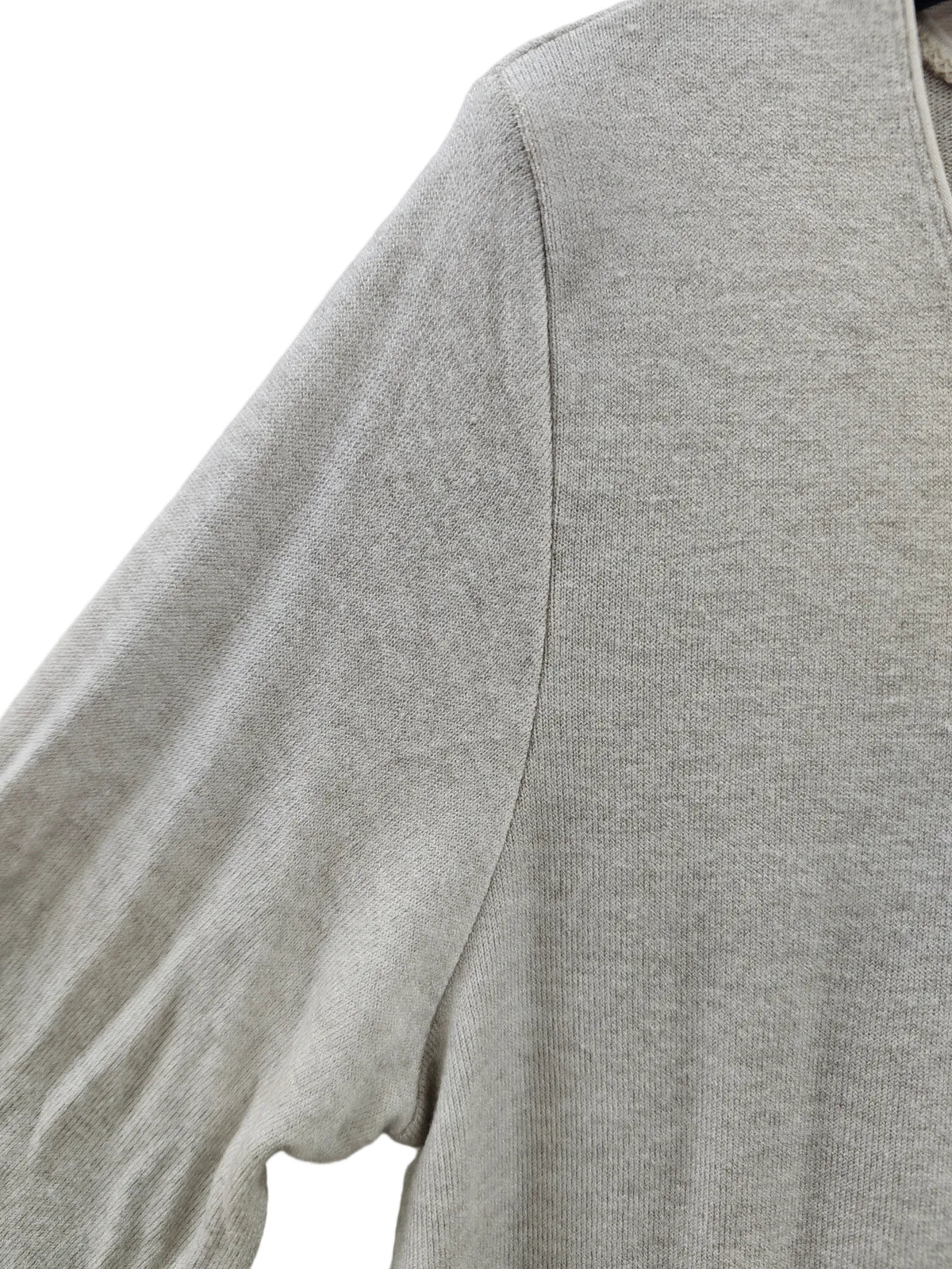 Close-up of a light heather gray knit top showing the shoulder seam and fine ribbed fabric texture.