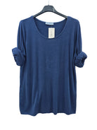 A navy blue long-sleeve top with rolled cuffs, hanging on a black hanger 