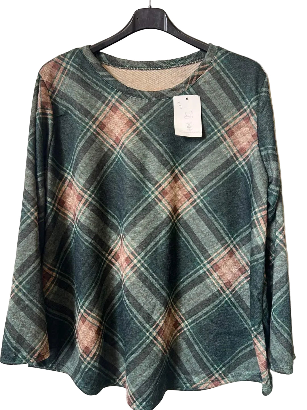 A women's long-sleeve plaid top hanging on a black hanger against a textured gray wall. The top features a muted green, brown, and beige tartan pattern