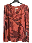 A rust-orange long-sleeve top with a dark reddish-brown leaf pattern, 