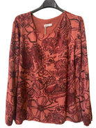A long-sleeve V-neck top with an all-over floral and paisley print in rust red and dark burgundy, 
