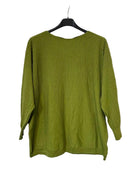 An olive green ribbed knit long-sleeve top hanging on a black hanger against a textured gray wall.