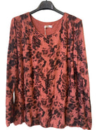 A long-sleeve crewneck top with a rust-orange and black camouflage print