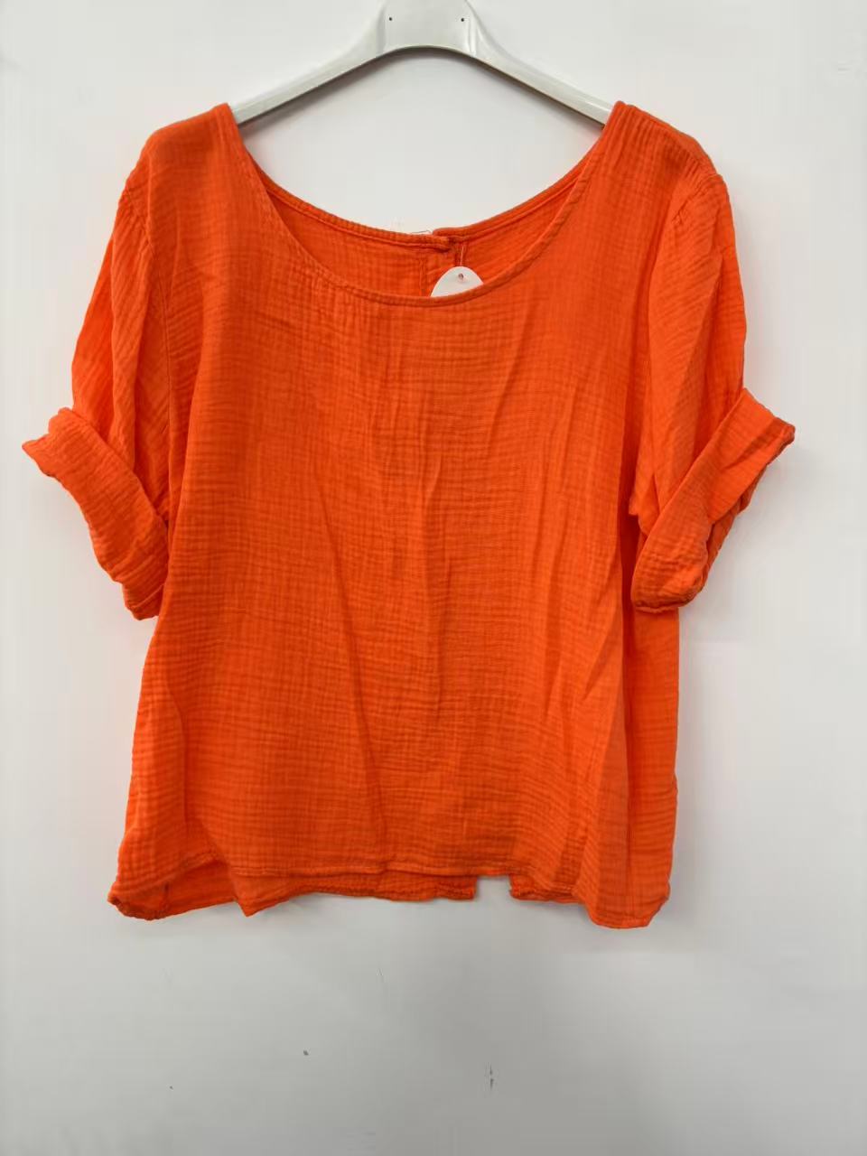 Orange shirt on a hanger against a white background
