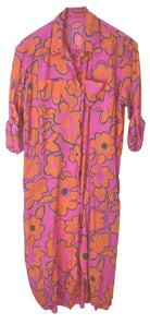 A pink and orange floral print shirt dress with a pointed collar and three-quarter sleeves, shown hanging against a plain white background.