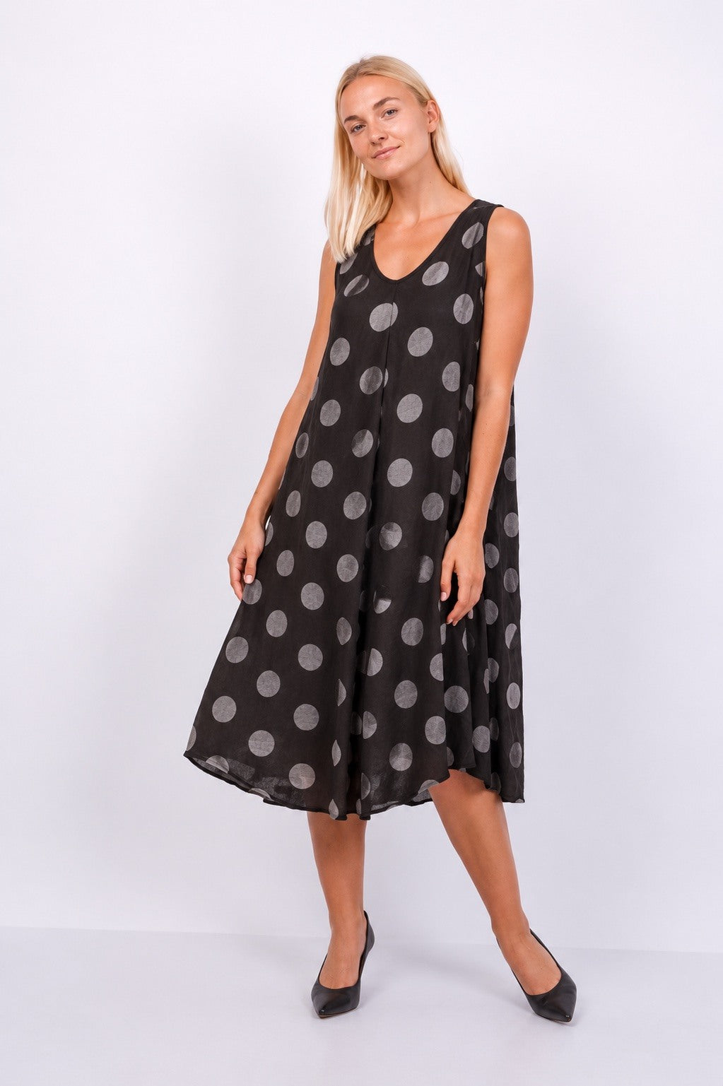 Woman wearing a chocolate dress with polka dots on a white background