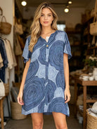 Woman wearing a blue patterned dress in a store setting