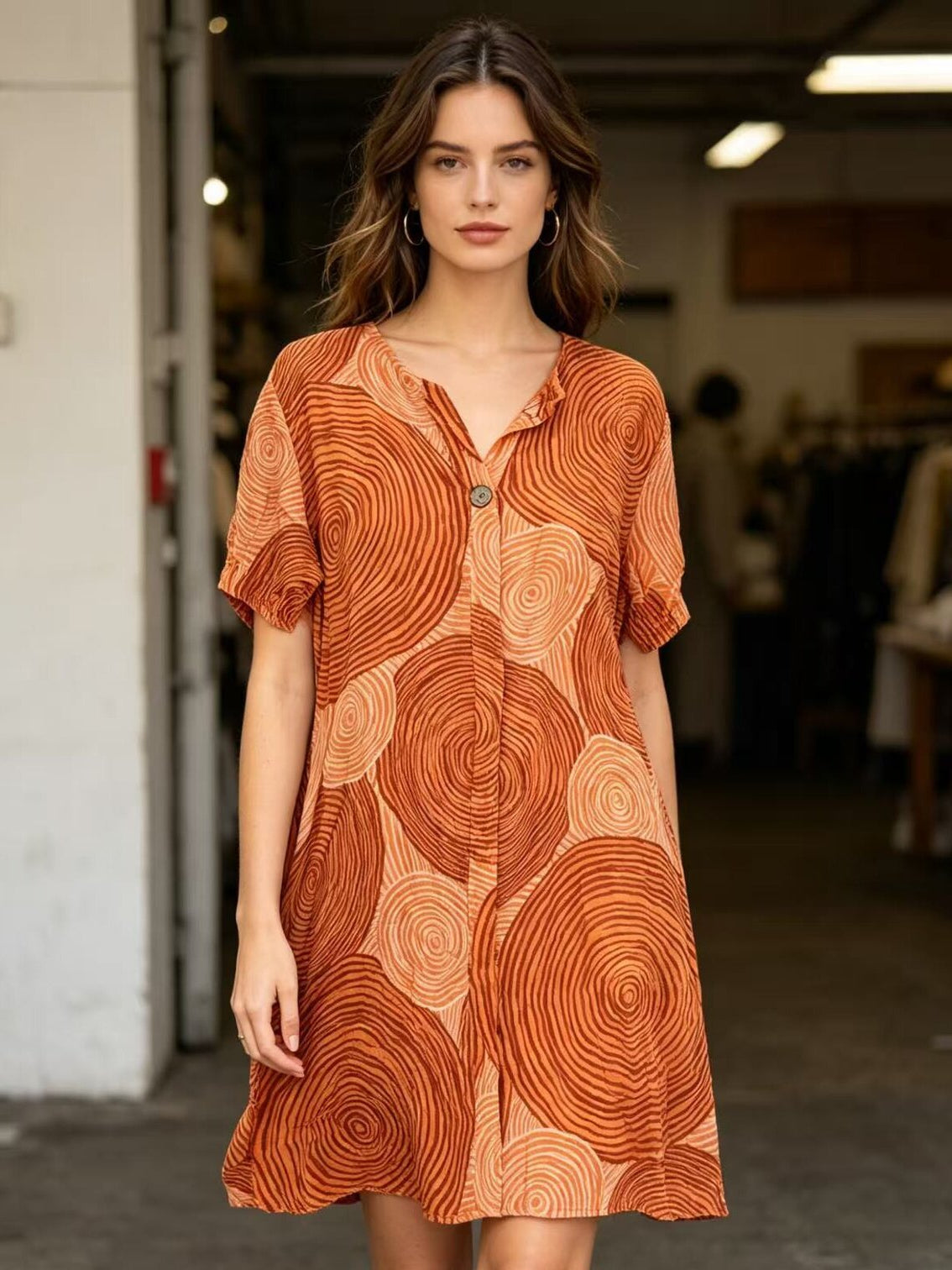 Woman wearing an orange patterned dress in a casual setting