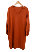 Orange dress on a hanger against a white background