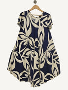 Navy and white patterned dress on a hanger against a plain background