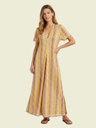 Woman wearing a yellow patterned dress on a white background