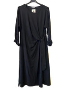 A black long-sleeve wrap-style dress with a draped front and side slit, 