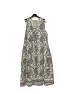 White dress with black floral pattern on a hanger against a white background