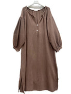A brown textured midi dress with balloon sleeves and a tassel tie neckline,