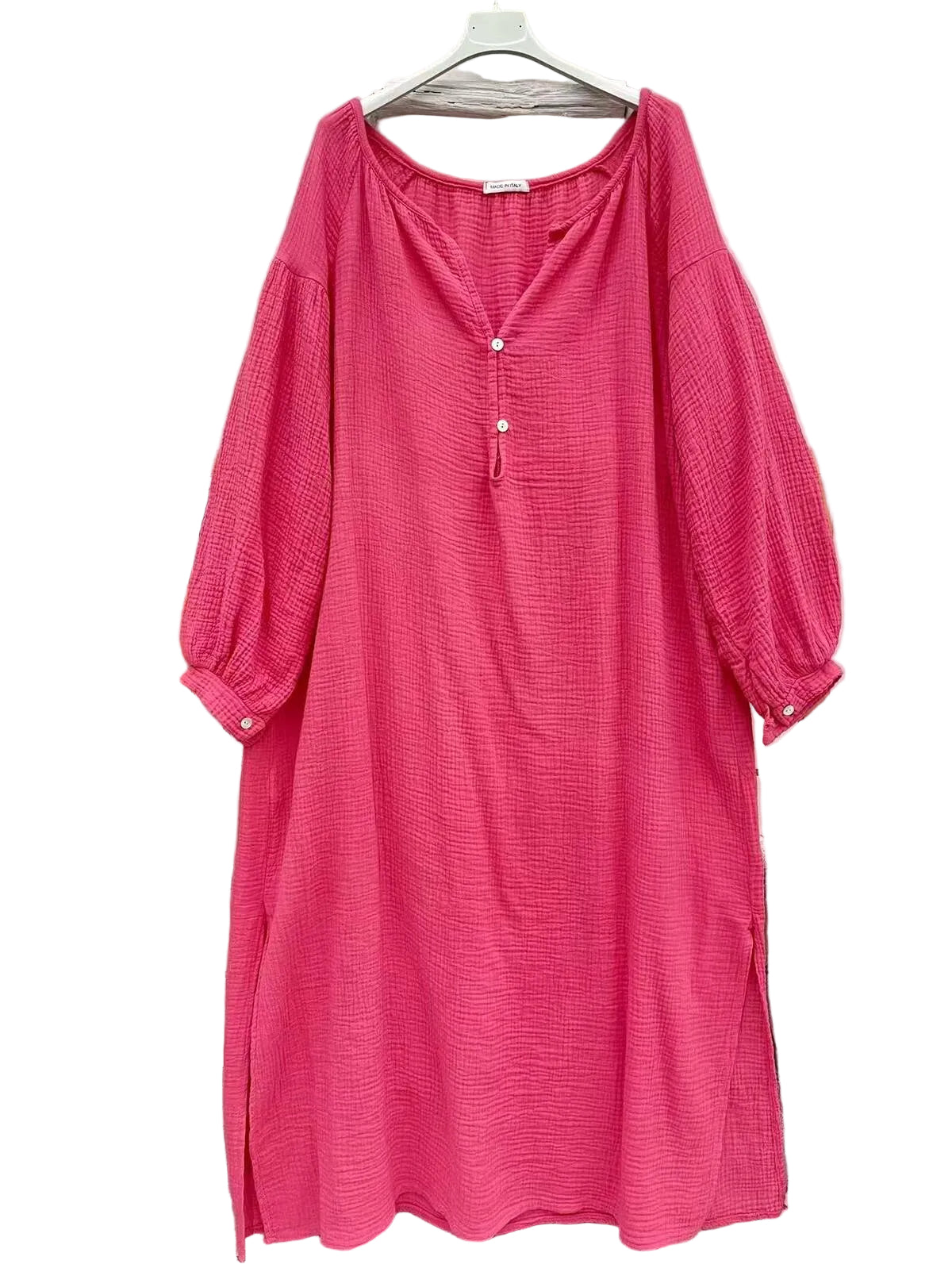 A bright pink textured cotton dress with a split neckline, three-quarter balloon sleeves,