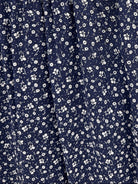 A sleeveless navy blue dress with a dense white daisy floral print