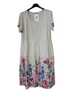 A short-sleeve beige dress with a colorful floral print concentrated along the hem