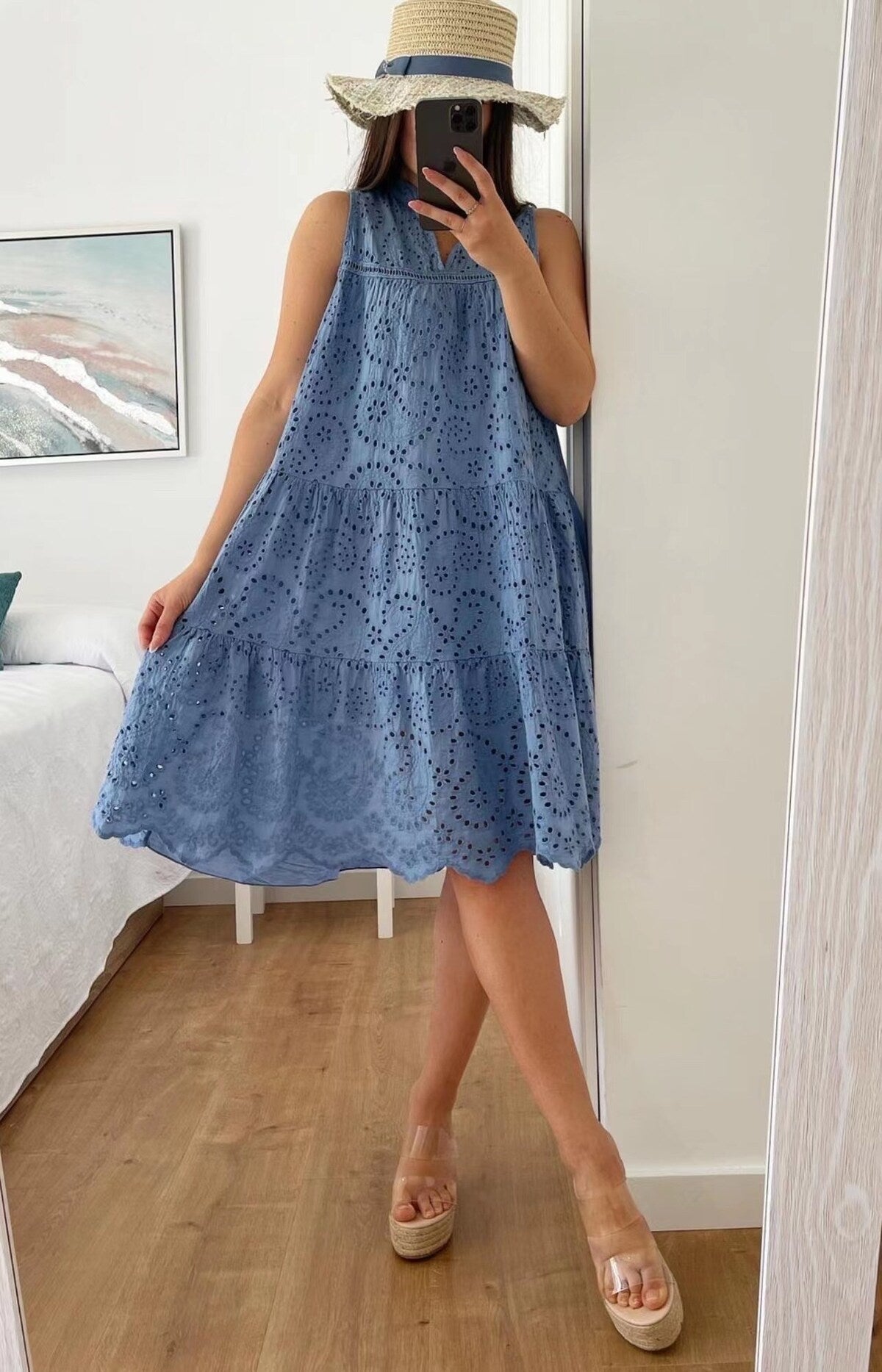 Person wearing a blue lace dress taking a mirror selfie.