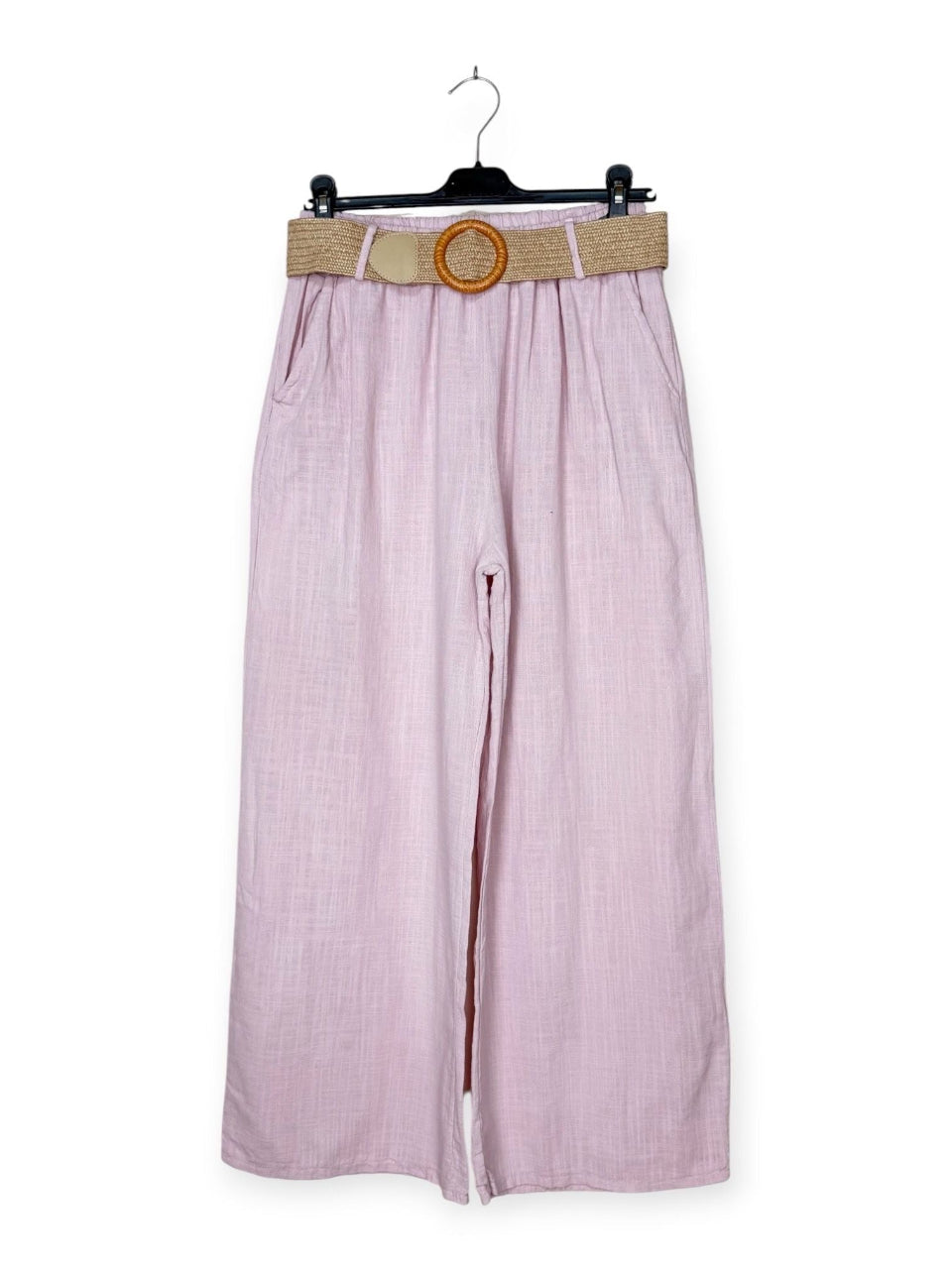 Pink trousers with a belt on a hanger against a white background