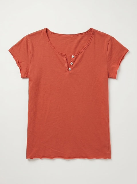 A short-sleeve henley t-shirt in a muted terracotta or burnt orange color, featuring a three-button placket, laid flat against a light gray background.