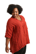 Woman wearing a rust top against a white background