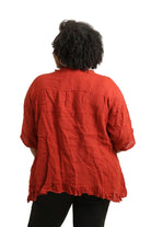 Person wearing a rust top from behind on a white background