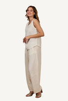 Woman wearing a sleeveless top and beige pants 