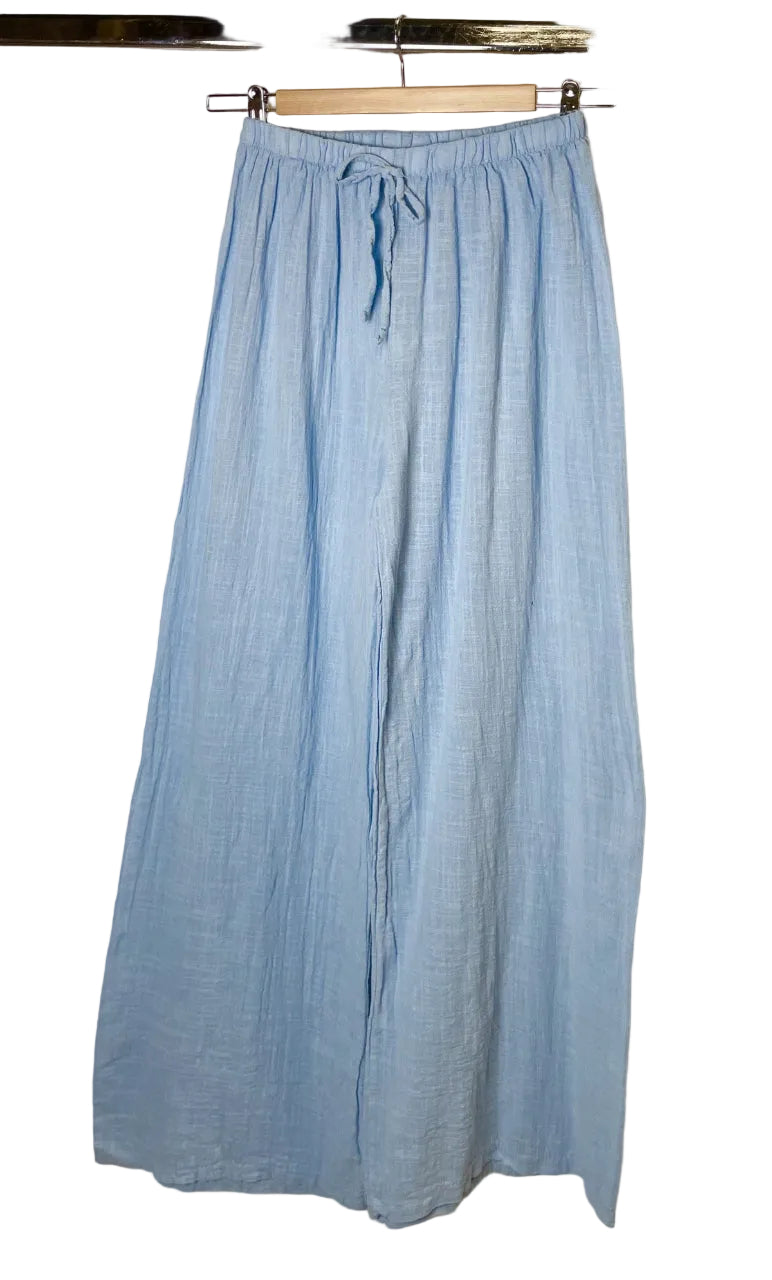 sky blue pants hanging on a rack against a white background