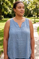 Woman wearing a blue sleeveless top in a park setting