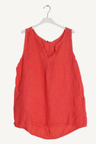 Coral sleeveless top on a white hanger 