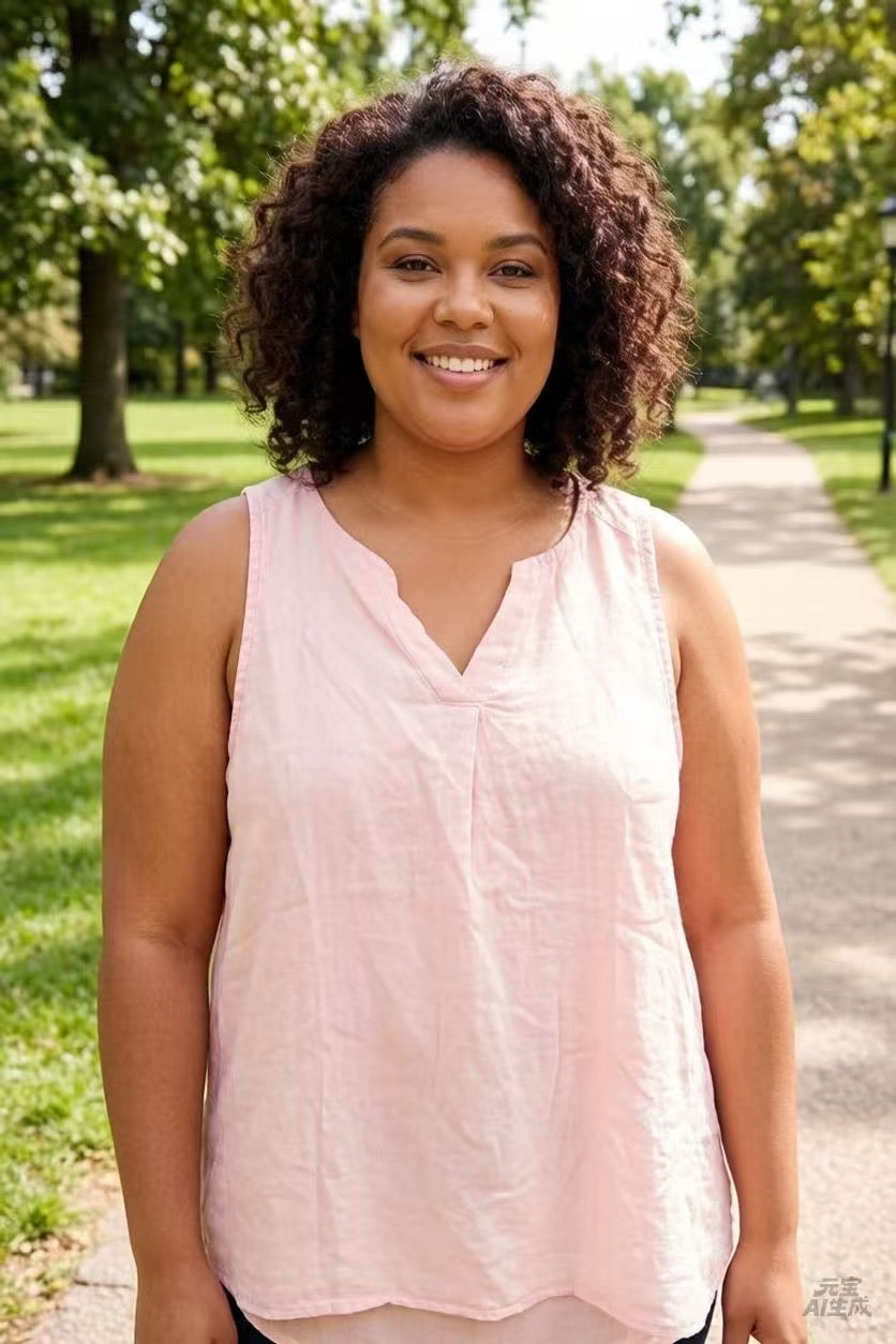 Woman in a pink sleeveless top standing on a path in a park.