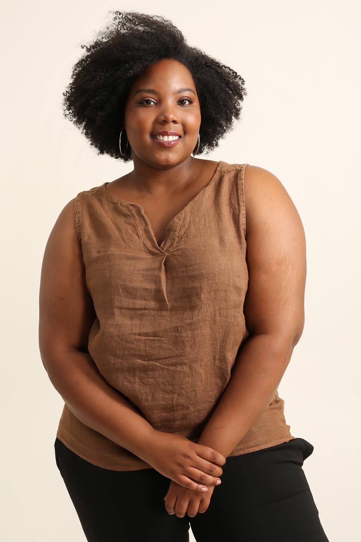 Woman wearing a brown sleeveless top against a beige background