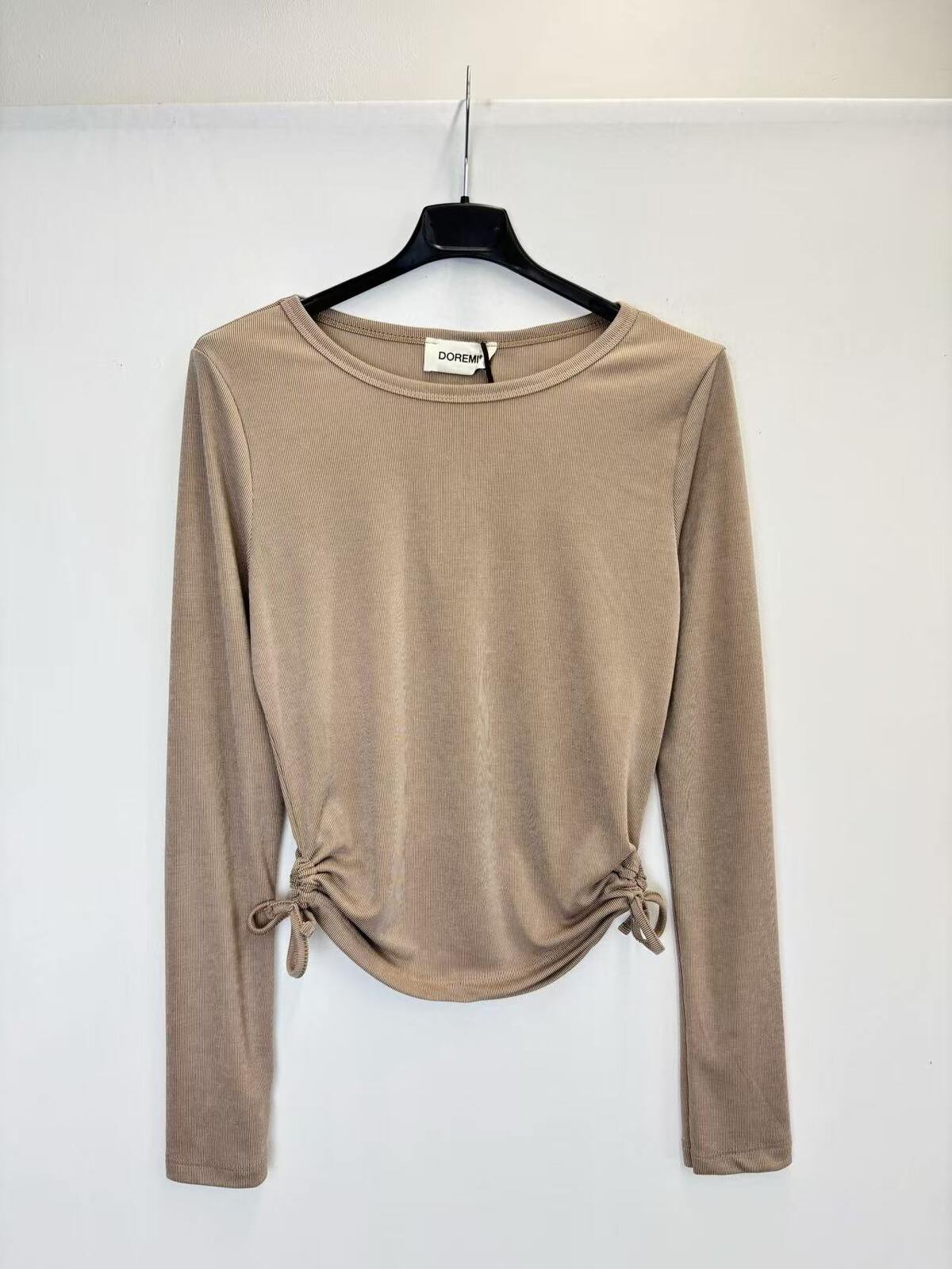 A beige long-sleeve knit top with side tie details