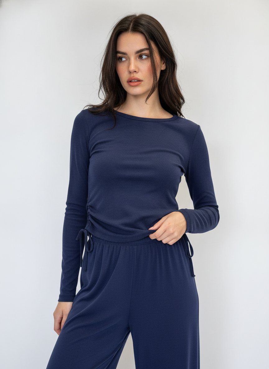 A woman modeling a navy blue long-sleeve ruched t shirt top with matching trousers