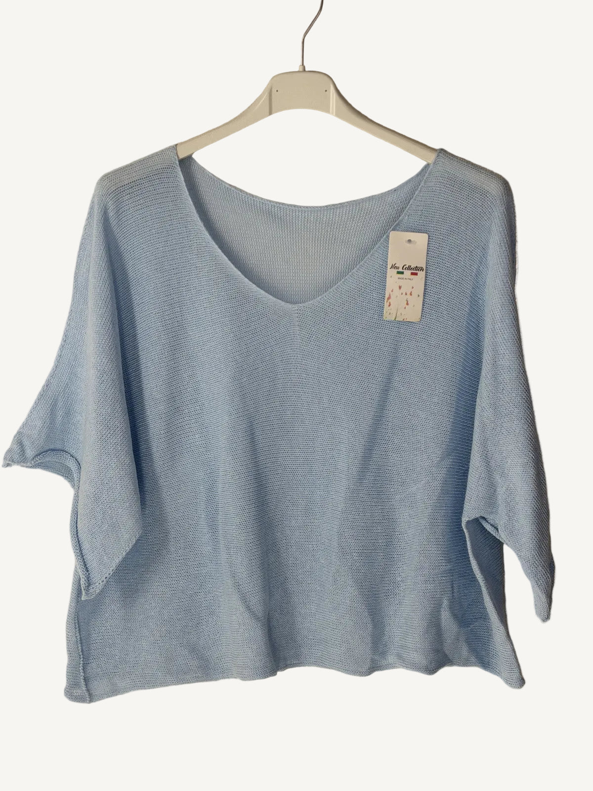 Light blue t-shirt on a hanger with a beige background