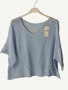 Light blue t-shirt on a hanger with a beige background