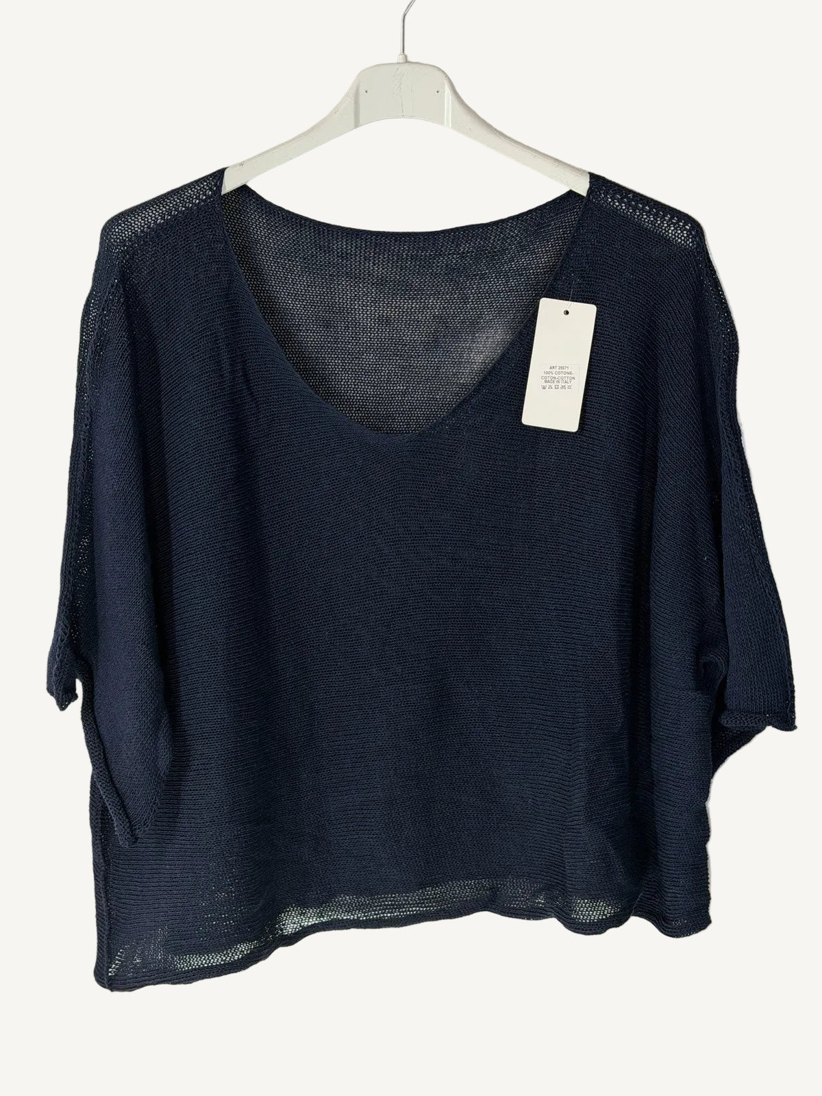 Black sweater with v neck on a hanger against a light background