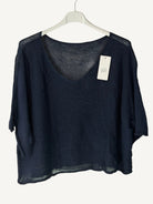 Black sweater with v neck on a hanger against a light background