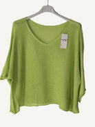 Green sweater with a v neck on a hanger 