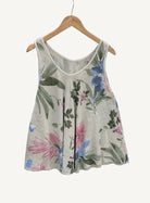 Floral-patterned sleeveless top on a hanger against a textured white background