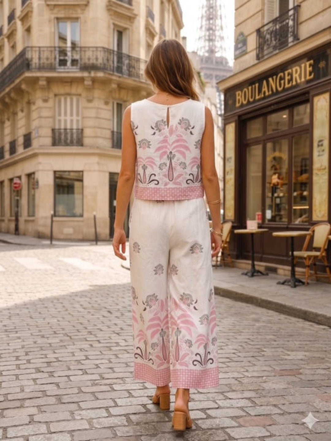 Woman in a floral two piece walking on a street with the Eiffel Tower in the background