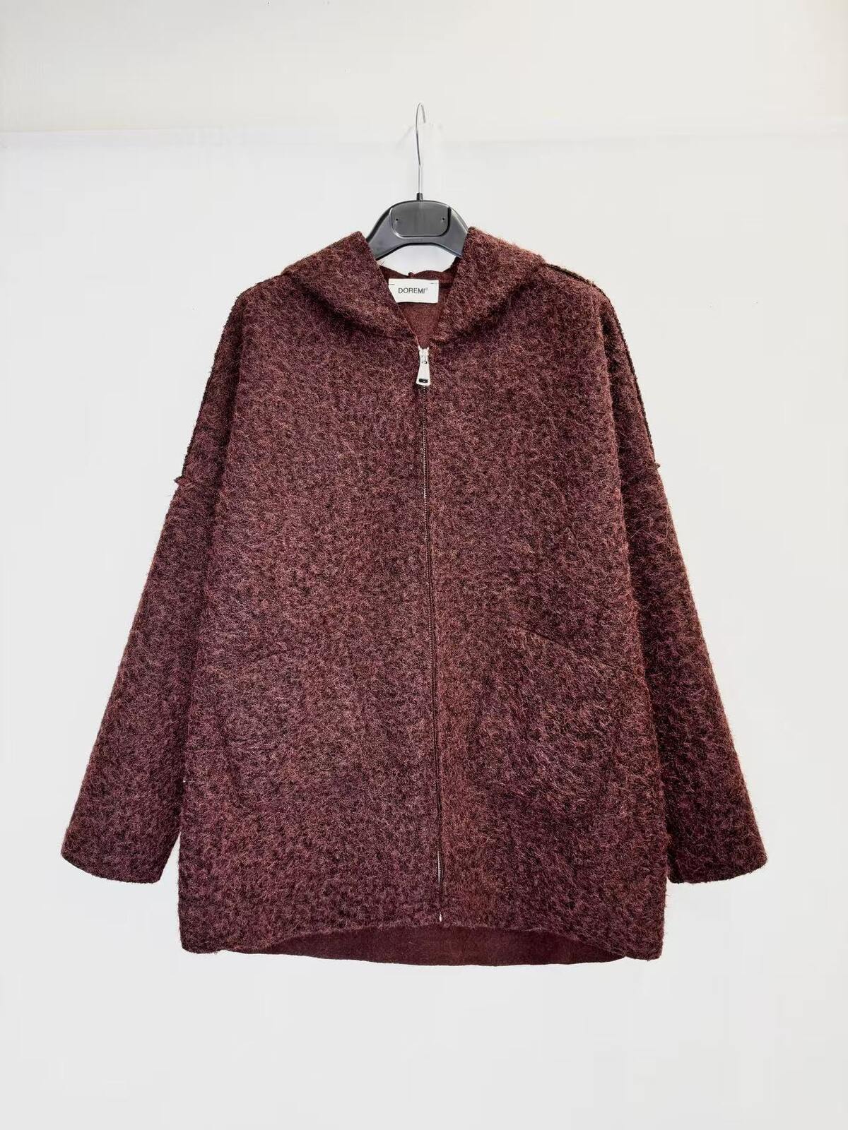 A textured, marled burgundy zip-up hoodie jacket hanging on a black hanger against a plain white wall.