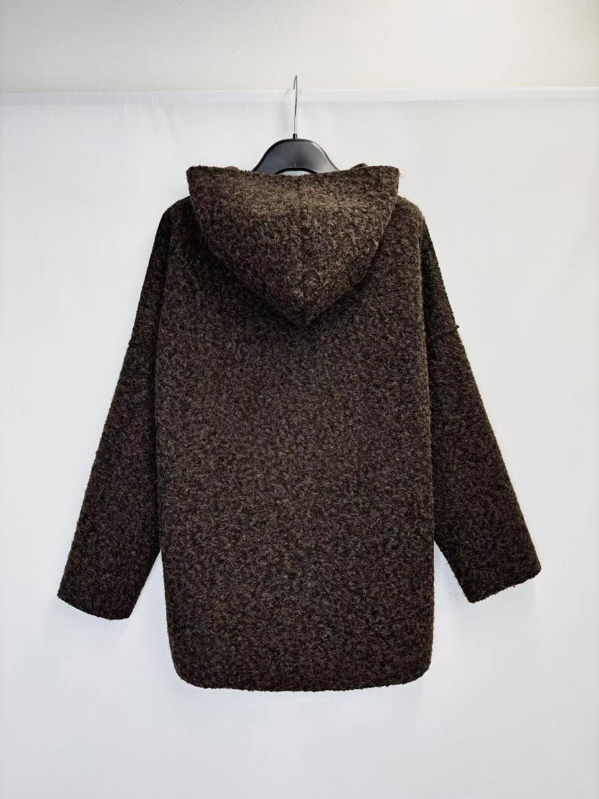 A dark brown textured knit hooded sweater hanging on a black hanger against a plain white background.