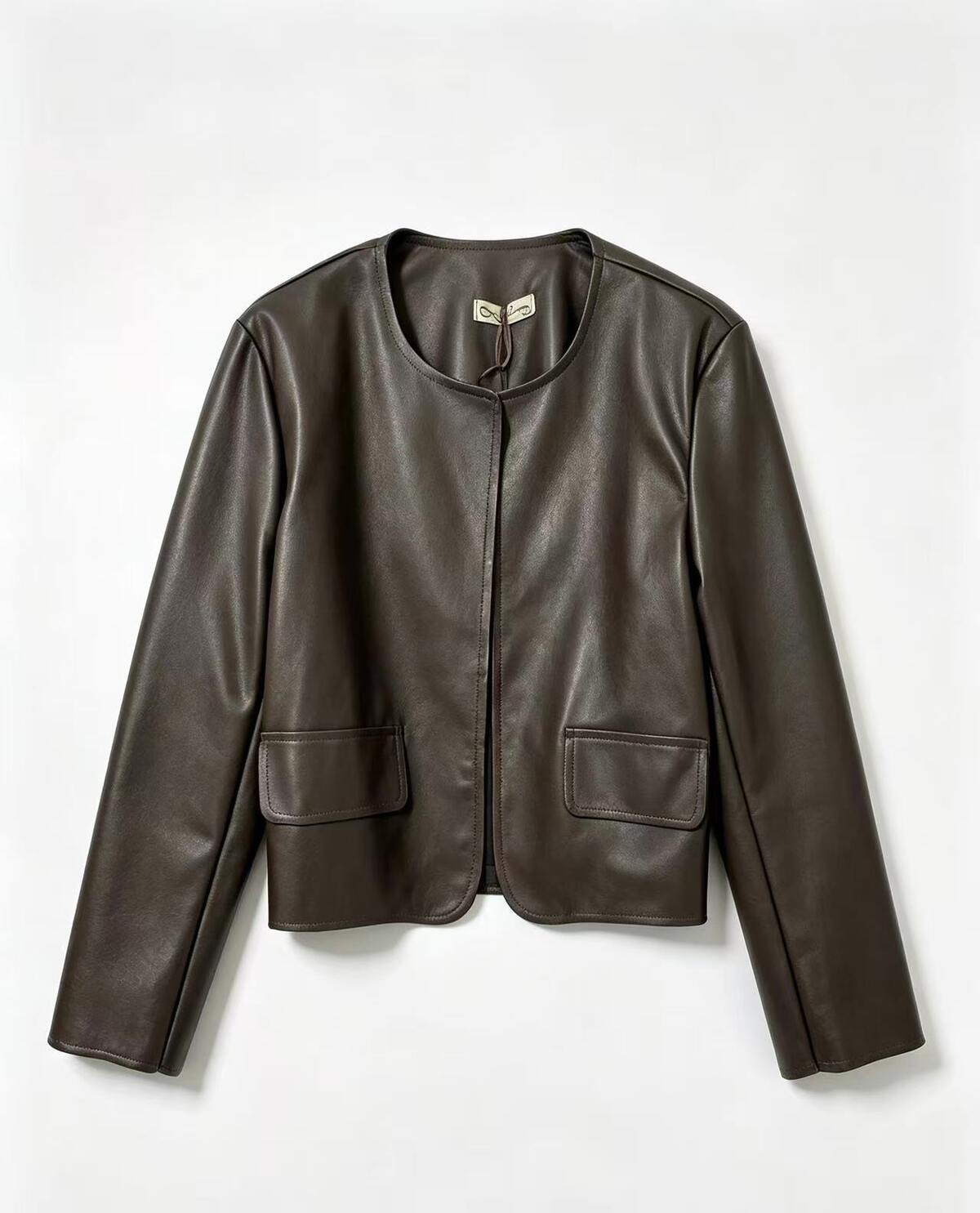 A dark brown faux leather jacket with a round neckline and two front flap pockets